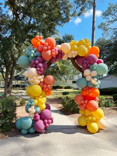 an arch made out of balloons in the shape of a letter o on a sidewalk