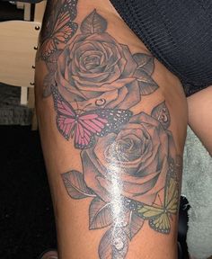 a woman's thigh with roses and butterflies on it