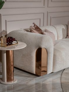 a white couch sitting next to a table on top of a marble floor