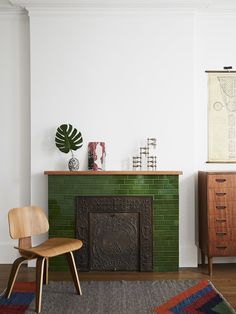 a living room with a green brick fireplace