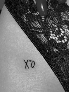 the word xo is written in black ink on a woman's lower back