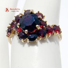 Dazzling 18K Yellow Gold Garnet Studded Cocktail Ring. The Garnets are round brilliant cut. This wonderful ring is a size 6 1/2 and weighs 3g. The larger Garnet measures 7mm in diameter and the smaller Garnets are 4mm in diameter. [nb457] Cocktail Ring, Silver Turquoise, Cocktail Rings, Round Brilliant, Flower Decorations, Charm Pendant, Beautiful Necklaces, San Jose, Earring Set