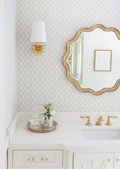 a bathroom vanity with a mirror, sink and gold faucet on it's side