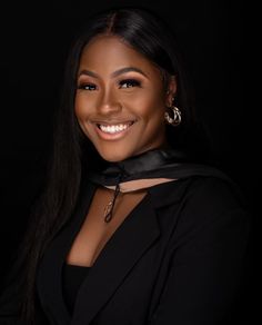 a woman with long hair wearing a black jacket and choker smiling at the camera