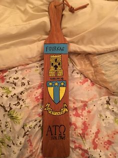 a wooden sign that says fukkaa ato and has an emblem on it