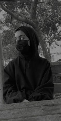 a person wearing a face mask sitting on a bench