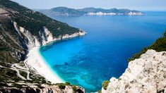 an aerial view of the blue water and white sand beach in croatia, with mountains in the background