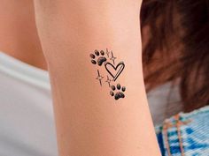 a woman with a tattoo on her arm and paw prints in the shape of a heart