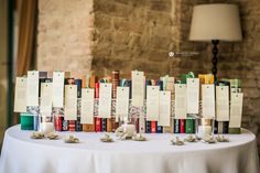 the table is set up with books and place cards on top of each bookcase