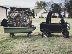 a black truck pulling a green trailer with a camouflage cover on it