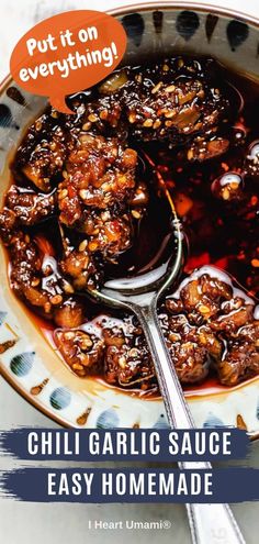 a bowl filled with chili garlic sauce next to a spoon on top of a plate