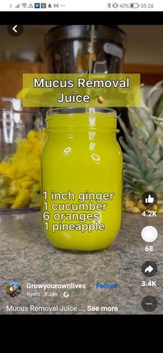 a yellow jar sitting on top of a counter next to pineapples and other fruit