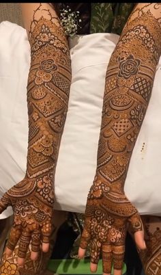 two hands with henna tattoos on them