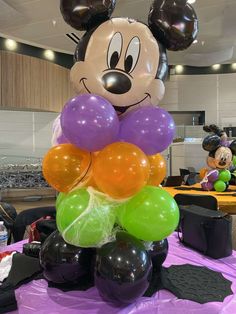 a mickey mouse balloon centerpiece on top of a table