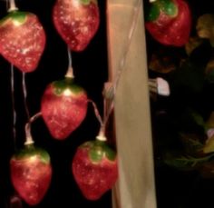 some red and green apples hanging from strings