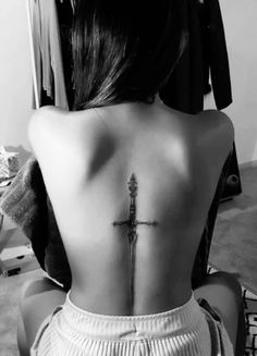 a woman with a cross tattoo on her back