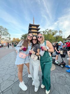 three women pose for a photo in front of the pagoda