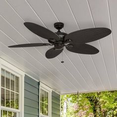 a ceiling fan on the outside of a house with blue siding and white shutters