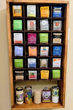 a wooden spice rack filled with lots of different types of spices on top of a wall