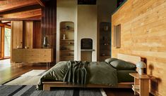 a bedroom with wood paneling and green bedding