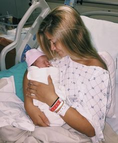 a woman holding a baby in a hospital bed