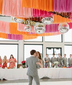 a bride and groom dance together in front of their wedding party at the reception table