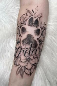 a black and white paw print with the word leo on it, surrounded by flowers