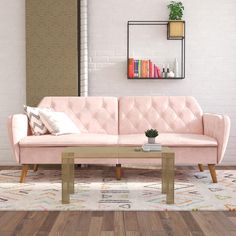 a pink couch sitting on top of a wooden table