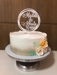 a white cake with flowers on top sitting on a table