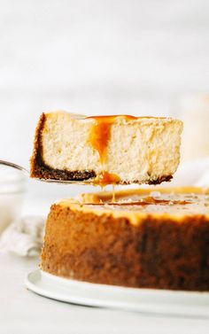 a slice of cheesecake being lifted from a cake