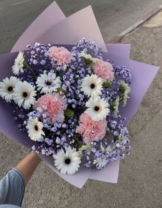 a person holding a bouquet of flowers on the street