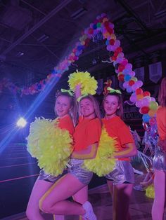 three girls in yellow and orange outfits posing for the camera