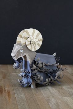 an origami horse is sitting on a wooden table and it's made out of paper