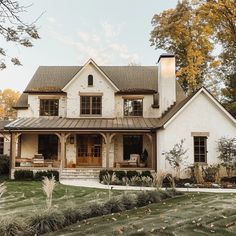 a large white house sitting on top of a lush green field