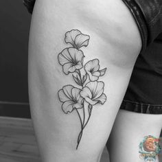 a black and white flower tattoo on the thigh