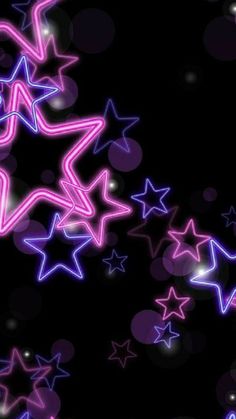 an abstract background with many stars in the dark, including pink and blue lights on black