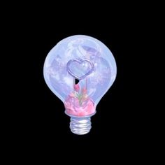 a light bulb with a heart shaped decoration on it's side and flowers in the bottom