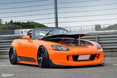 an orange sports car with its hood open