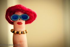 a finger doll with sunglasses on it's head and a ring around its thumb