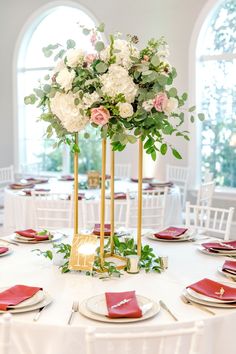 the centerpieces on this table are gold, white and pink flowers with greenery