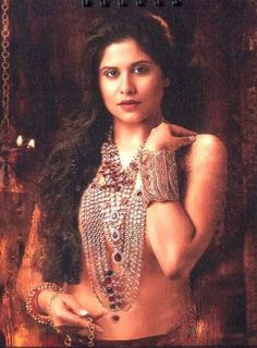 an image of a beautiful woman with jewelry on her chest and arm, posing for the camera