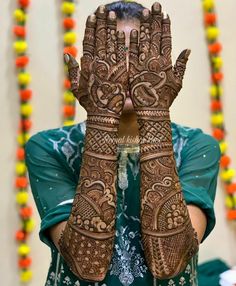 a woman holding her hands up to show the hendi