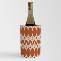 a bottle of wine sitting inside of a paper cup with an orange and white pattern on it