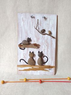 three cats sitting on top of a wooden shelf