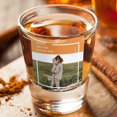 a glass filled with liquid sitting on top of a wooden table next to cinnamon sticks