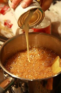 a person pouring liquid into a pot filled with food