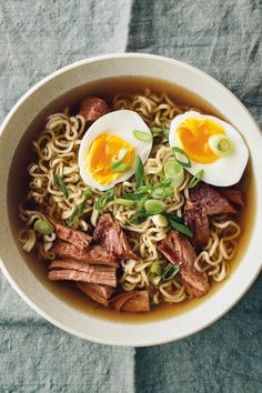 a bowl filled with noodles, meat and eggs