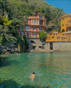 people swimming in the water near some buildings