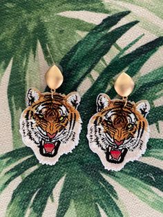 Go Tigers! Take a walk on the wild side in these fiercely roaring tiger dangle earrings. Fashioned from vividly colored embroidered tiger patches and hung from gold tone eye shaped finials, these earring are sure to show your tiger pride, spirit and enthusiasm.  Total Length: 3 inches Total Width: 2 inches Lightweight for a comfortable wear! Tiger Roar, Embroidered Tiger, Tiger Roaring, Go Tigers, Walk On The Wild Side, Aesthetic Desktop Wallpaper, Take A Walk, Eye Shapes, Finials