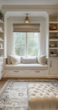 a large window seat in the corner of a room with built - in shelving